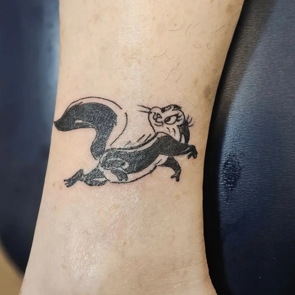 Small Penelope Pussycat tattoo positioned near the ankle