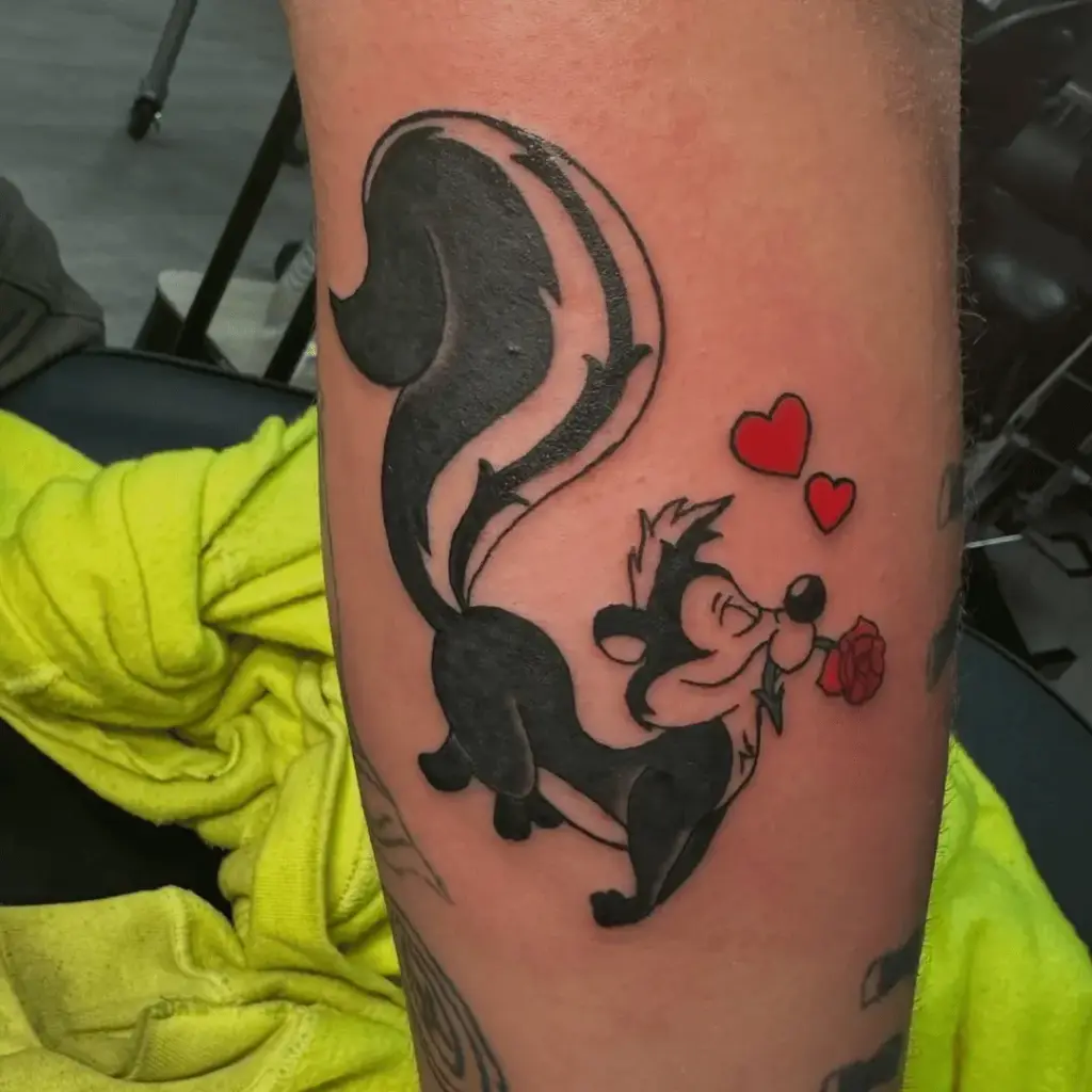 Pepé Le Pew arm tattoo with bold black outlines and color