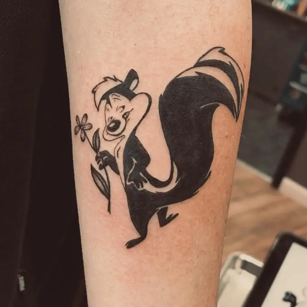 Full-color Pepé Le Pew tattoo on the inner forearm