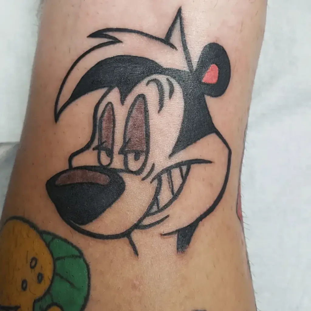 Pepé Le Pew tattoo positioned above the knee