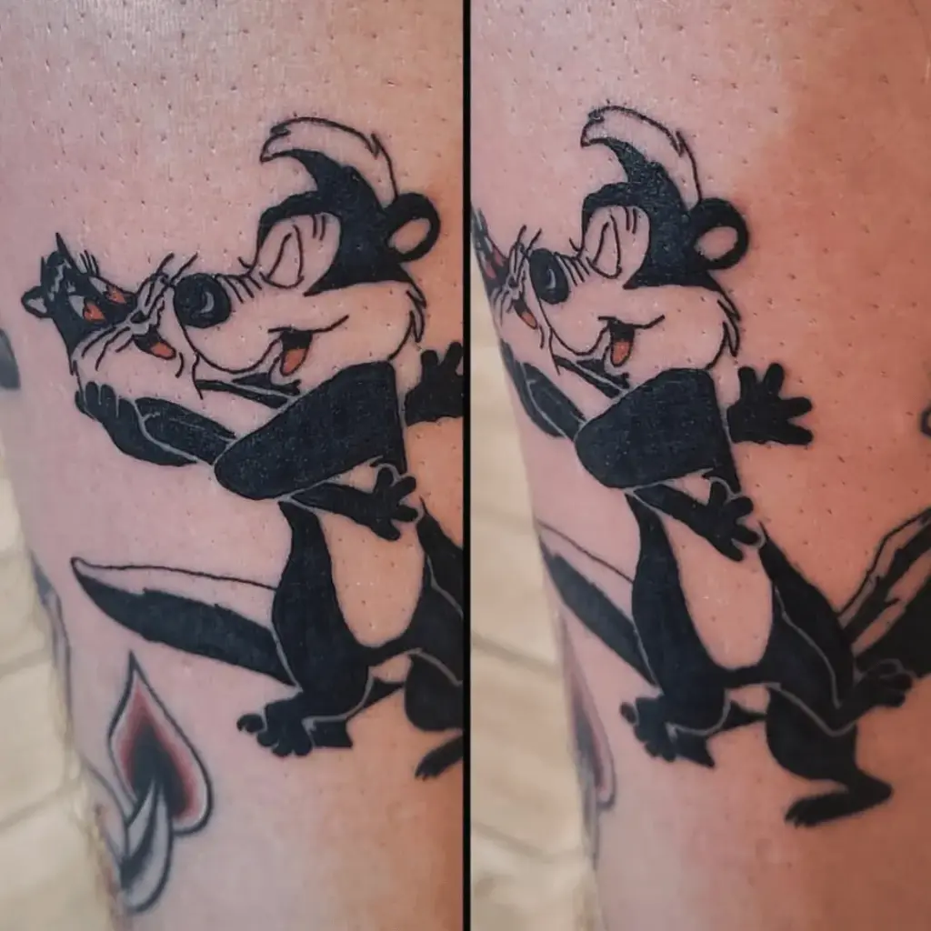 Close view of a colorful Pepe Le Pew and Penelope leg tattoo