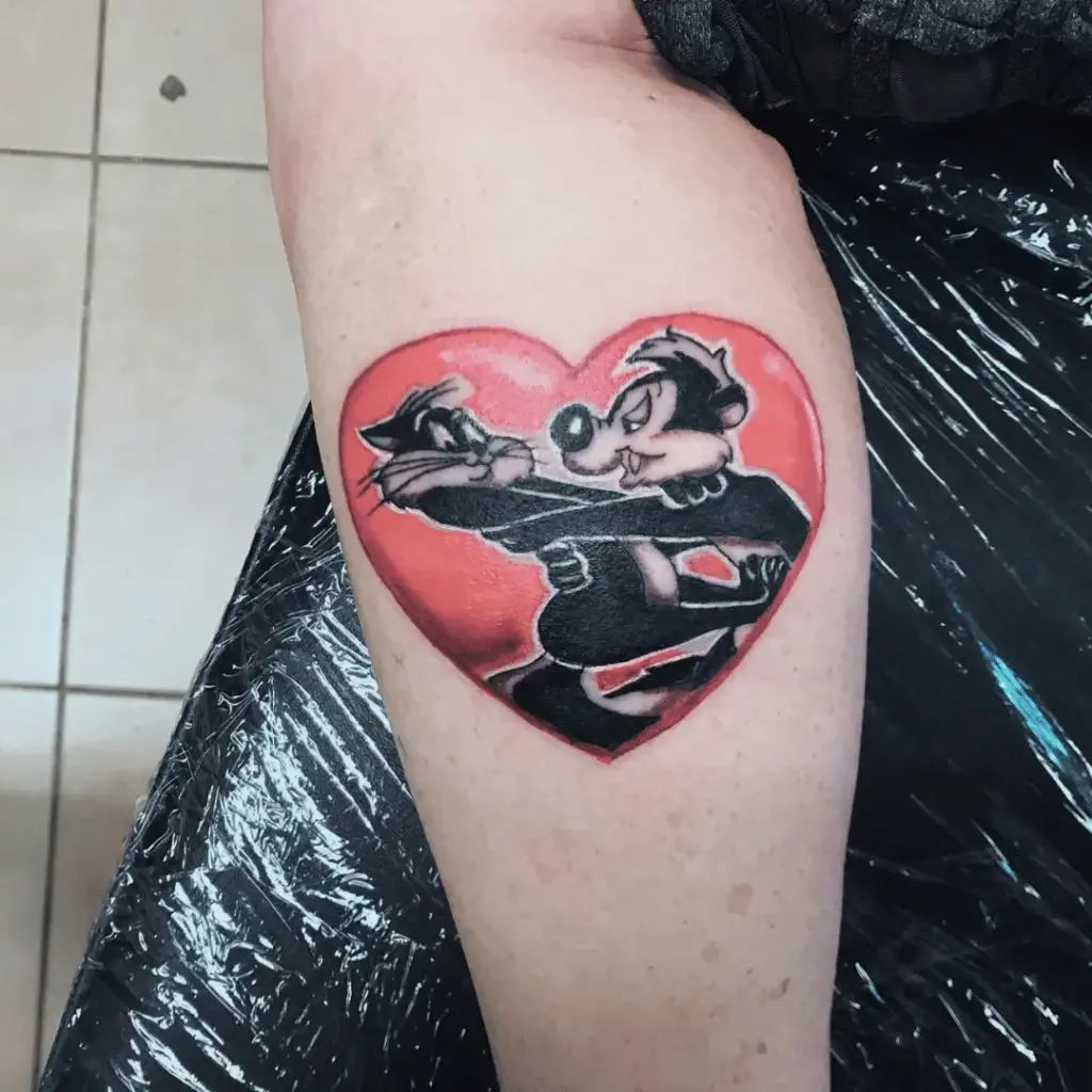 Full-color Pepé Le Pew cartoon tattoo on the calf