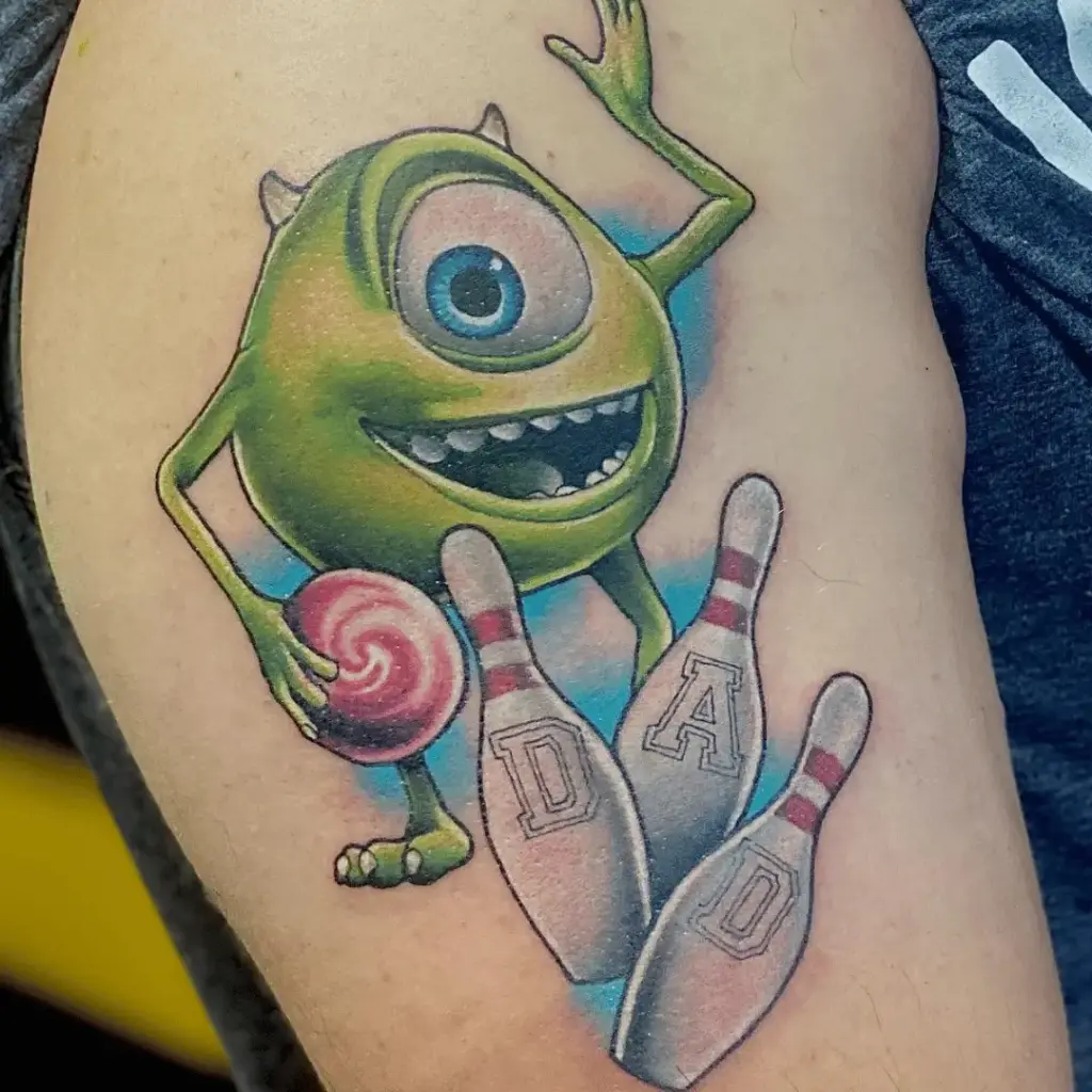 Funny full-color Mike Wazowski tattoo on the upper arm