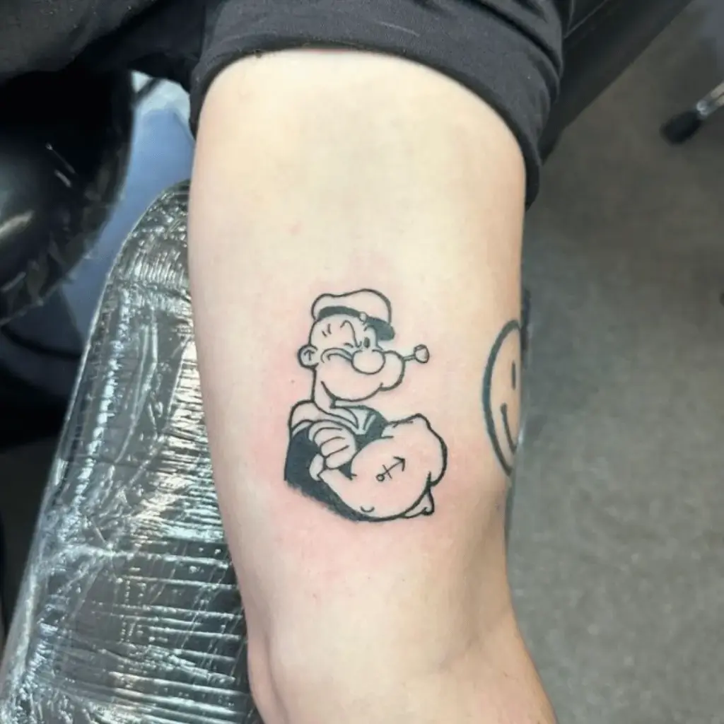 Small full-color Popeye tattoo on the thigh