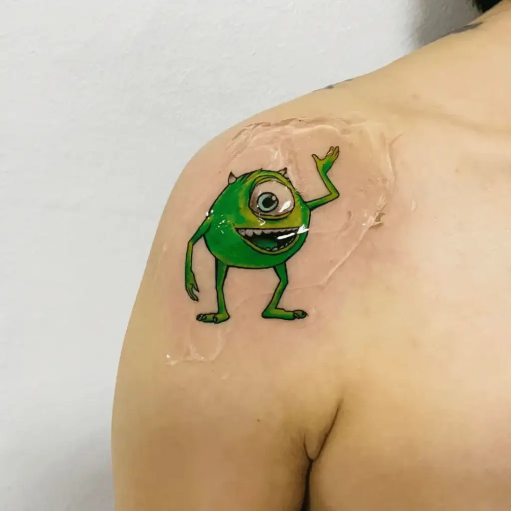Small full-color Mike Wazowski tattoo on the shoulder